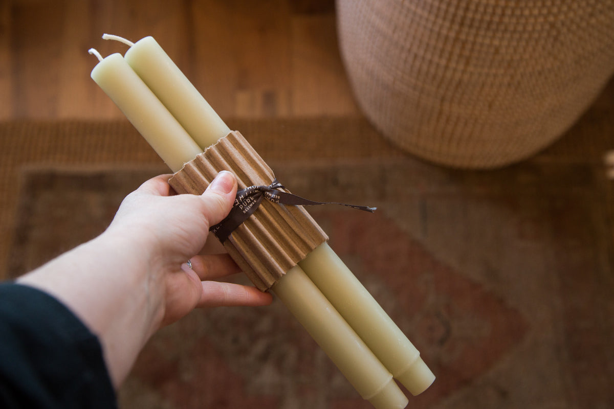 Pair of celadon beeswax church taper candles bundled in corrugated cardboard.