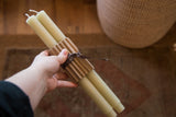 Pair of celadon beeswax church taper candles bundled in corrugated cardboard.