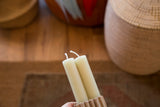 Smooth texture and white wicks of two celadon beeswax church taper candles.