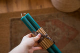 Pair of turquoise beeswax taper candles, 12 inches, with corrugated wrap and brown ribbon.