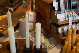 Smooth cream beeswax column taper candle standing upright with a visible wick.