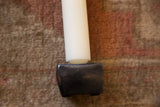 Close-up of the matte black cast iron candle holder base, with candle.