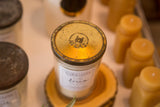 Aged golden zinc lid with ATLAS logo on a vintage jelly jar candle.