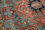 Rectilinear Heriz pattern in blush, sea foam green, and indigo with time-softened pile texture.