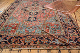 Vintage Heriz carpet corner, rectilinear patterns in blush, indigo, and sea foam green, with copper chair.