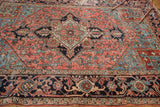 Rectilinear geometric border of vintage Heriz rug in blush, sea foam, indigo, and charcoal, showing wear.