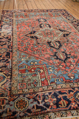 Geometric border and time-softened texture of a vintage Heriz rug in blush and indigo.