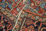 Patinaed pile and visible foundation on a vintage Heriz rug, highlighting rectilinear patterns.