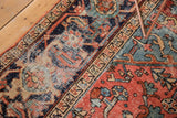 Vintage Heriz carpet detail showing rectilinear border, terra cotta field, and exposed foundation.