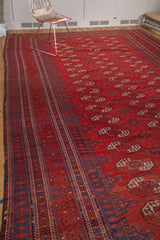 Intricate traditional border and gul motifs on a red and indigo Afghan Bokhara carpet.