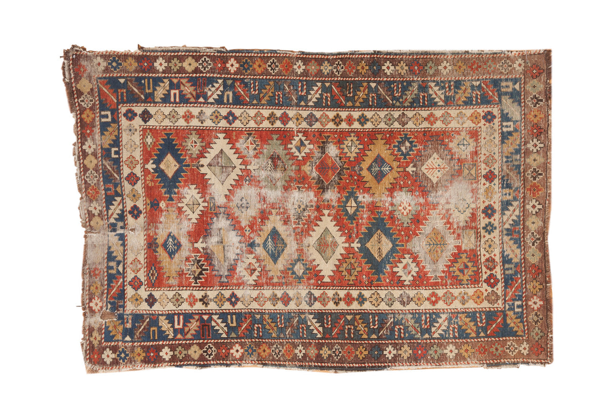 Antique Caucasian Shirvan rug, madder red and navy gul medallions, with time-softened texture.