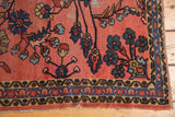 Vintage Lilihan rug's low pile, faded cranberry field, indigo border patterns, and tattered edge.