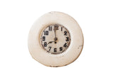 Vintage hand-painted folk art clock with distressed cream frame and dark, worn numerals.