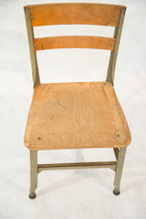 Vintage Toledo kid's chair featuring a light green metal frame and well-used wooden seat.