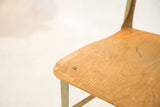 Corner of vintage Toledo chair seat with chips, marks, and light green metal.