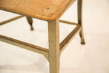 Light green metal leg of a vintage Toledo kid's chair, displaying worn paint.
