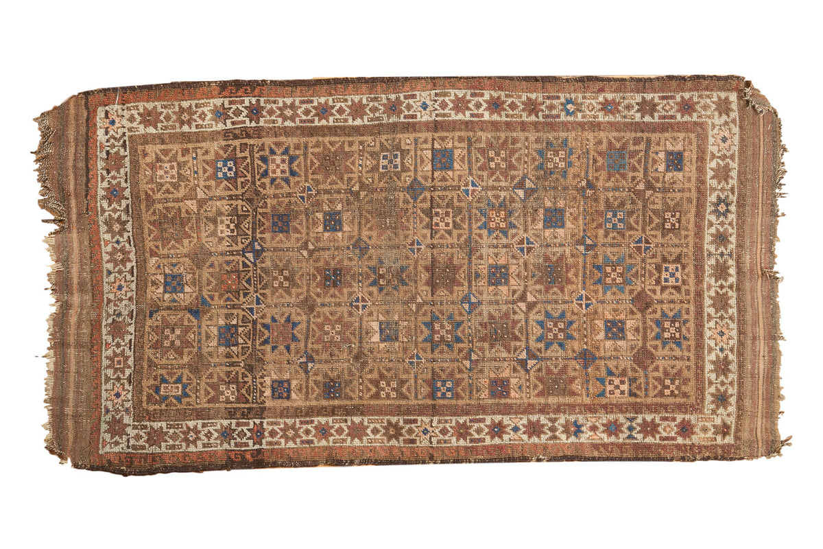 Antique Belouch rug runner, geometric repeating starburst gul and pinwheel motifs in camel, blue, red.