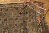 Antique Belouch rug corner with camel, sky blue, madder red starburst gul motifs, and tattered fringe.