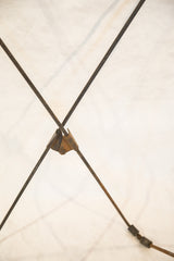 Rusted metal rods intersecting with a vintage bracket on the butterfly chair frame.