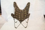 Black metal butterfly chair frame displaying geometric black and beige fabric pattern.