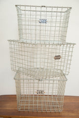 Stack of three Mid Century industrial gray wire baskets with numbered tags.