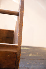 Primitive vintage wooden toolbox side detail, showcasing aged wood grain and rich patina.