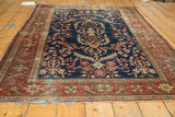 Antique Farahan Sarouk rug corner showing terra cotta border and visible fraying.