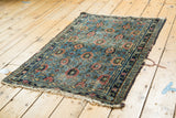 Antique Lilihan rug corner: veramin lattice, splayed madder red florals, dark indigo border, tattered fringe.