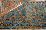 Corner of antique Lilihan rug, with veramin floral field, rich indigo border, and wear.