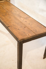 Reclaimed wood planks with knots meeting the dark, textured industrial metal frame.