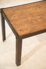 Corner view of reclaimed wood tabletop and textured industrial metal leg.