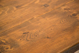 Close-up of reclaimed wood surface, highlighting natural knots and rich brown grain.