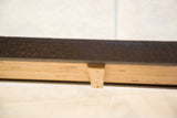 Reclaimed Industrial Bench Table underside, revealing light wood grain and dark metal base.