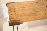 Reclaimed wood coffee table showing rustic top and industrial metal corner bracket.