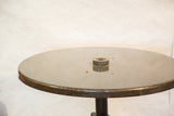 Detail of the industrial bistro table's dark green charcoal top and central hardware.