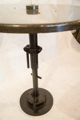 Dark green industrial bistro table's adjustable threaded metal pole and round base.