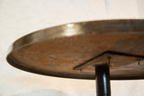 Reclaimed industrial bistro table underside, with dark base and textured metal.
