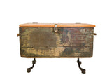 Reclaimed industrial trunk with distressed green, maroon paint, rope handles, black legs.