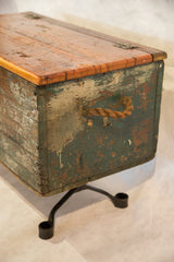 Distressed green-blue and brown paint texture, natural rope handle, and industrial leg on trunk.