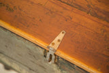Industrial trunk's weathered wood top, faded green side, and distressed metal latch.