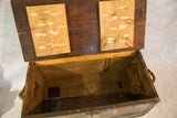 Open vintage industrial trunk interior with rustic wood and rope handle.