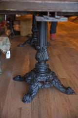 Ornate vintage iron table base with detailed foliate carvings and a fluted column.