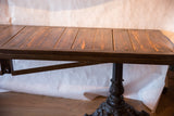 Side view of the reclaimed wood plank top and ornate vintage iron pedestal base.