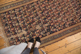 Vintage Hamadan rug's allover boteh paisley pattern with visible wear and exposed foundation.
