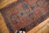 Antique Hamadan rug's central diamond medallion with sky blue, blush, and worn floral patterns.