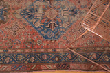 Distressed border and tattered edge of antique Hamadan rug, faded blue, blush motifs.