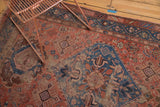 Antique Hamadan rug detail: worn blush field with pinwheels, blue diamond medallion, and oversized palmettes.