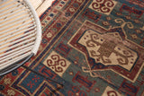 Antique Fachralo Kazak rug with worn pile, geometric, and rams horn motifs.
