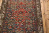 Mir Serbend border framing distressed tangerine, sky blue Herati motif on vintage Hamadan fragment.