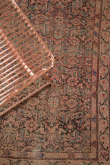 Antique Persian Malayer rug with distressed Herati pattern in blush, charcoal, and teal tones.